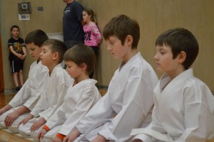 Young members meditate after karate practice.